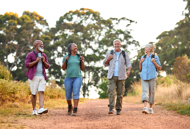 group of active senior friends walking outdoors together annuities for retirement